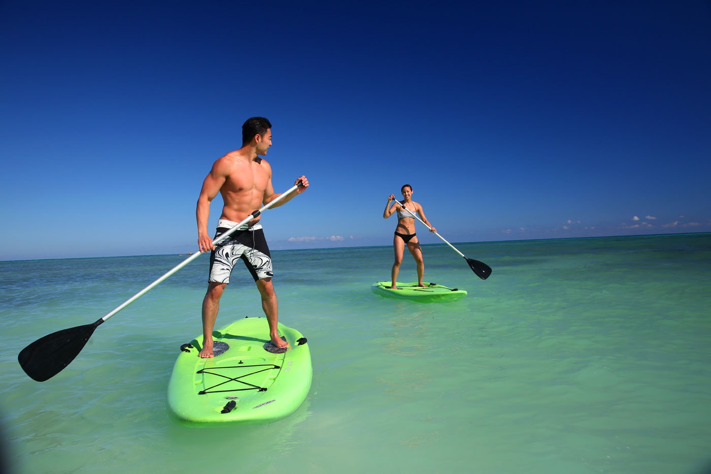 Guests paddleboarding on crystal-clear Caribbean waters at Royalton Hideaway