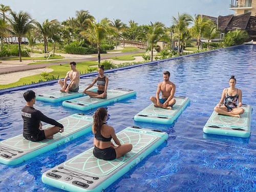Group fitness class on floating mats in the resort pool